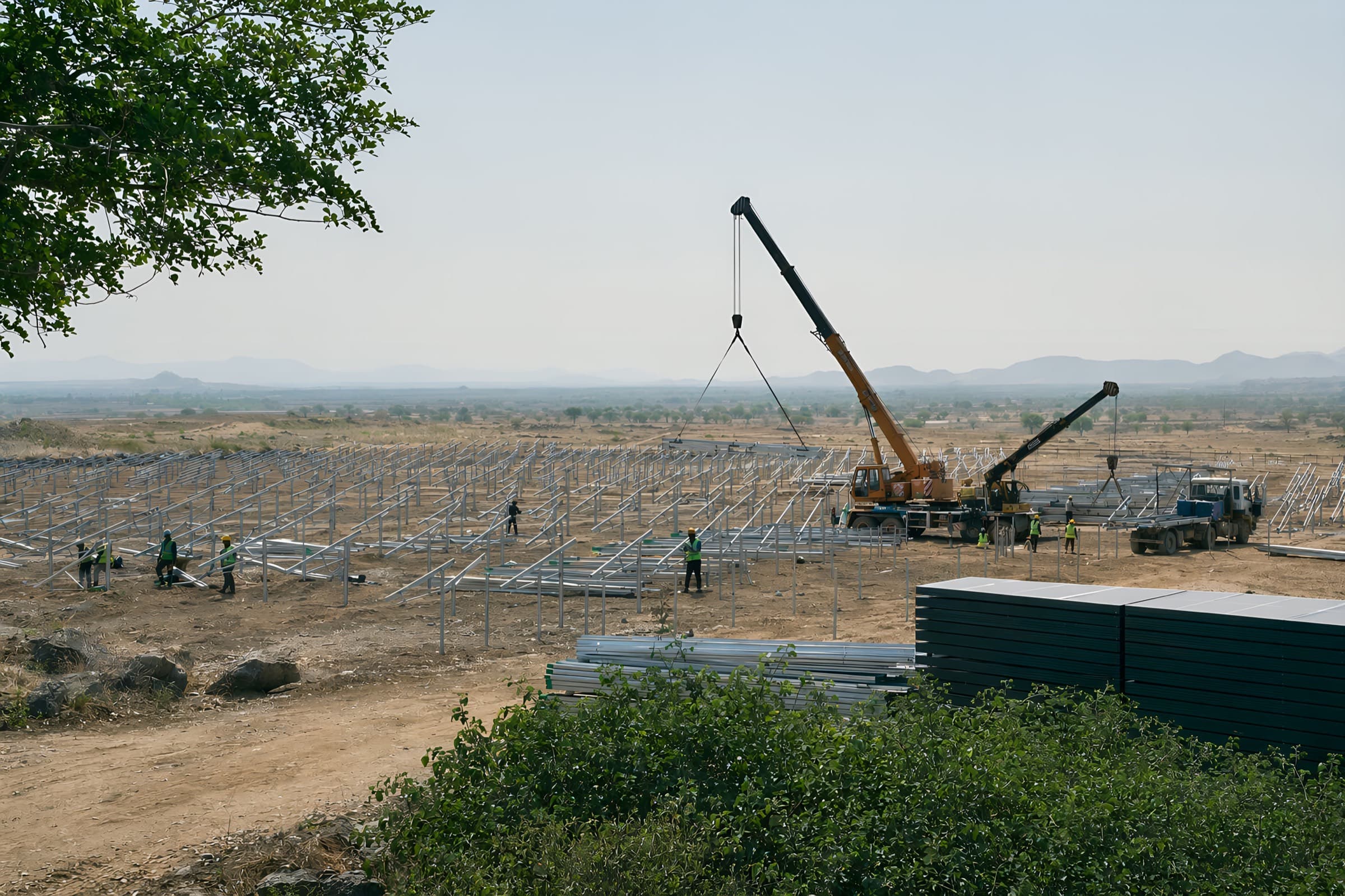 A solar park under construction, with a crane setting the structures